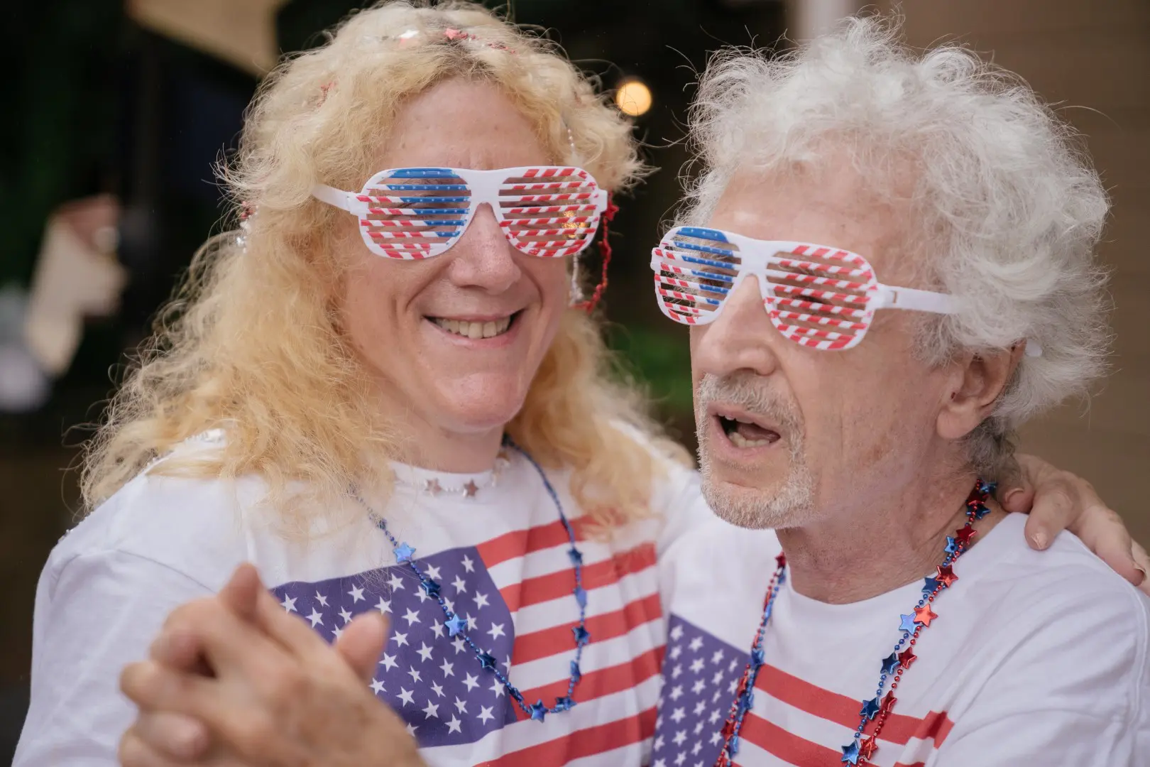 A man and woman wearing american flag glasses.